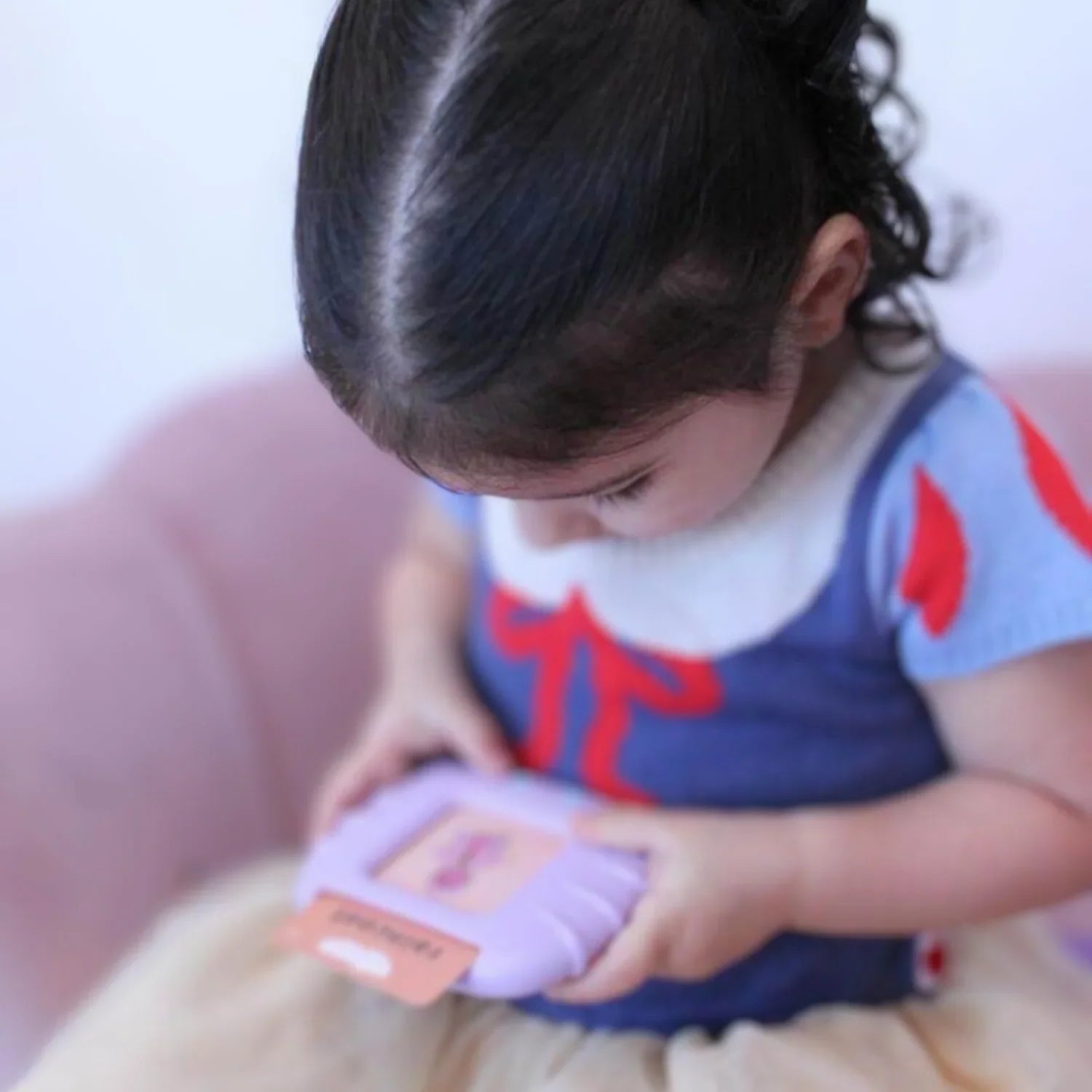 Djevojčica koristi ljubičasti KinderSpeech uređaj za učenje govora s karticama za interaktivni razvoj ranih jezičnih vještina.