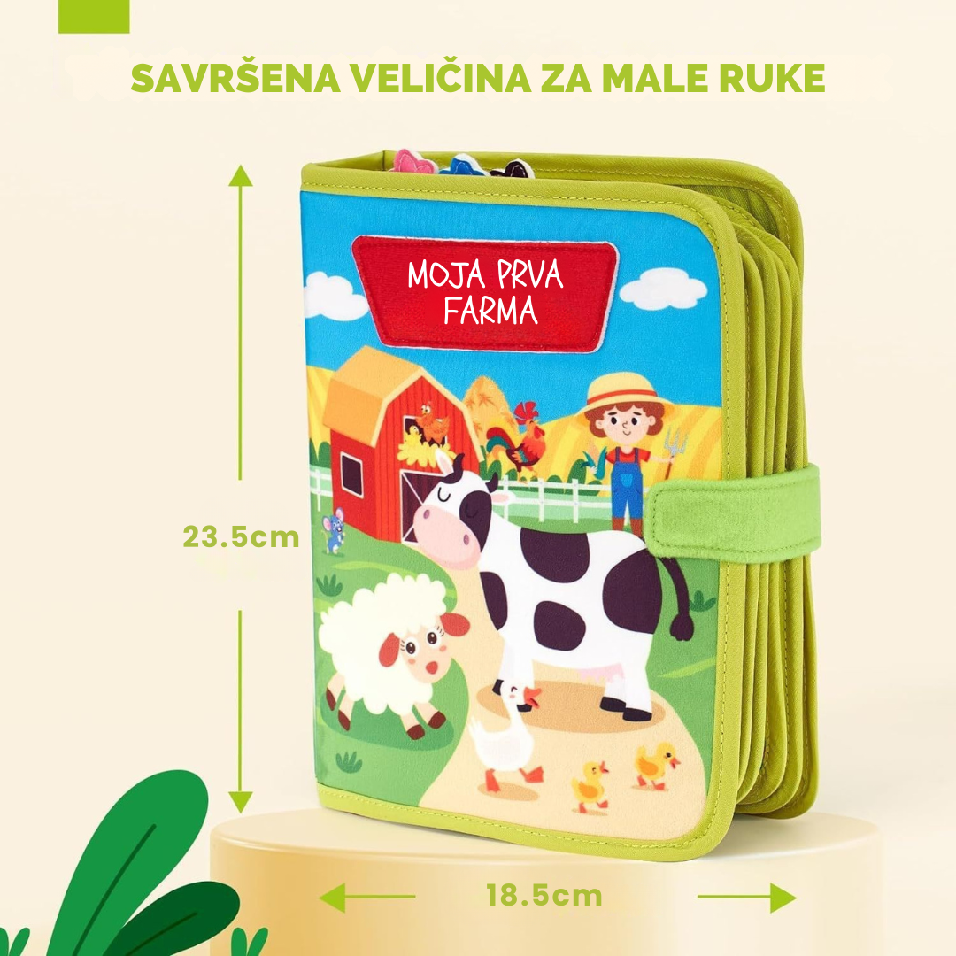 Promotivna slika senzorne knjige "Moja prva farma" koja prikazuje njezine dimenzije: visinu od 23,5 cm i širinu od 18,5 cm. Na slici je istaknut tekst "SAVRŠENA VELIČINA ZA MALE RUKE", a naslovnica knjige prikazuje ilustracije krave, ovce i farmera na farmi.